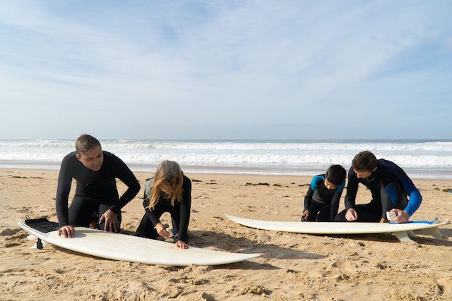 A group of people preparing their boards for a Surf School Lesson