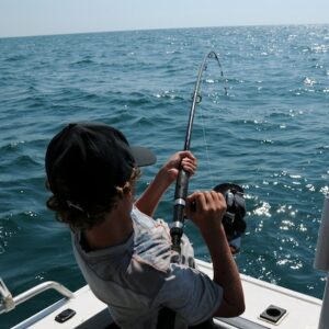 A man fishing off the back of a boat
