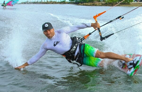 A Kite Surfer having a great time smiling at the camera