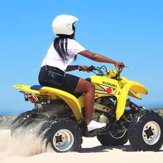 Headout quad bike tours. A girl enjoying the sand dunes